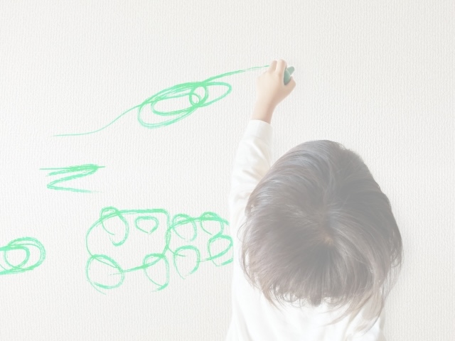 壁にラクガキをする子ども